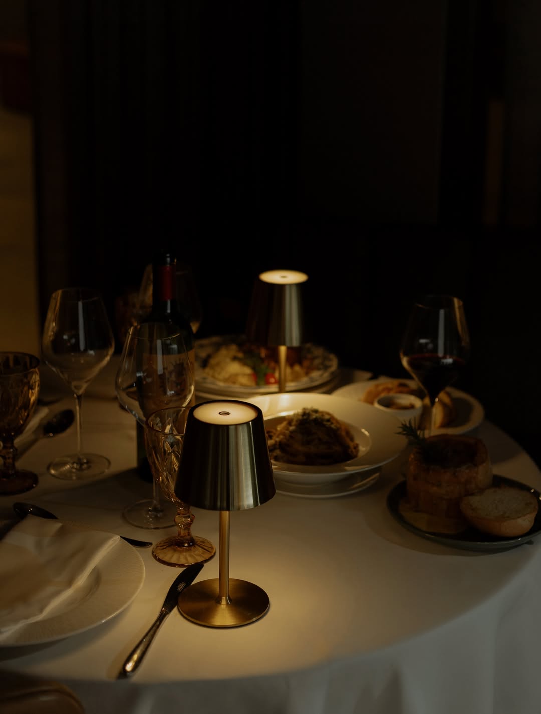Mesa iluminada por luminária de latão no salão à noite