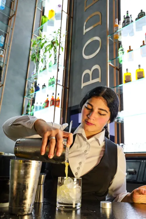 Bartender da Bodega preparando um drink no balcão